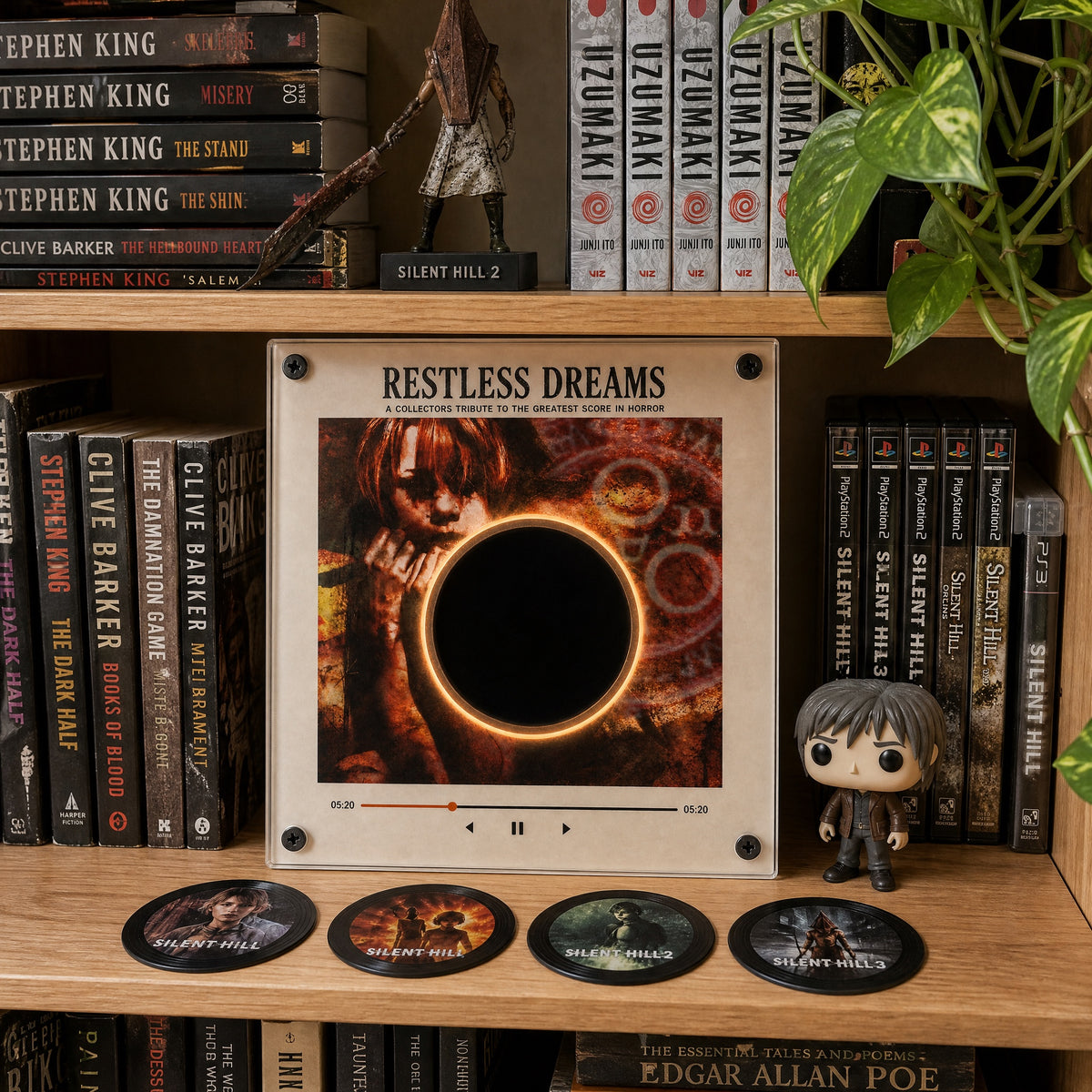 Silent Hill vinyl player displayed on a collector's shelf with horror books and games